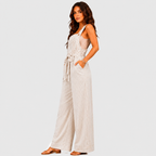 Side view of white striped wide leg jumpsuit with tie waist and sleeveless design by BELLA HUDSON