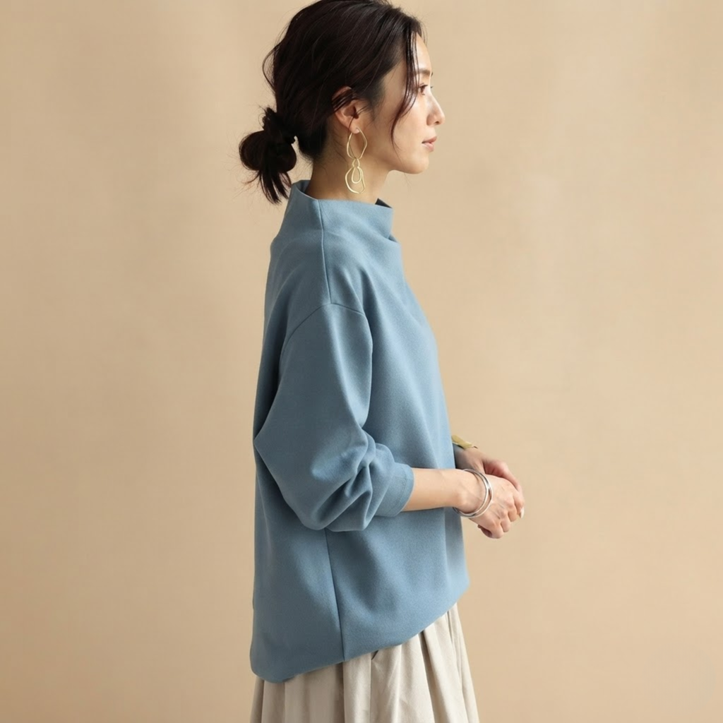 Side view of the Wilhelmina Blouse Draped High-Neck Long-Sleeve in Blue, showcasing its relaxed draped fit and long sleeves.