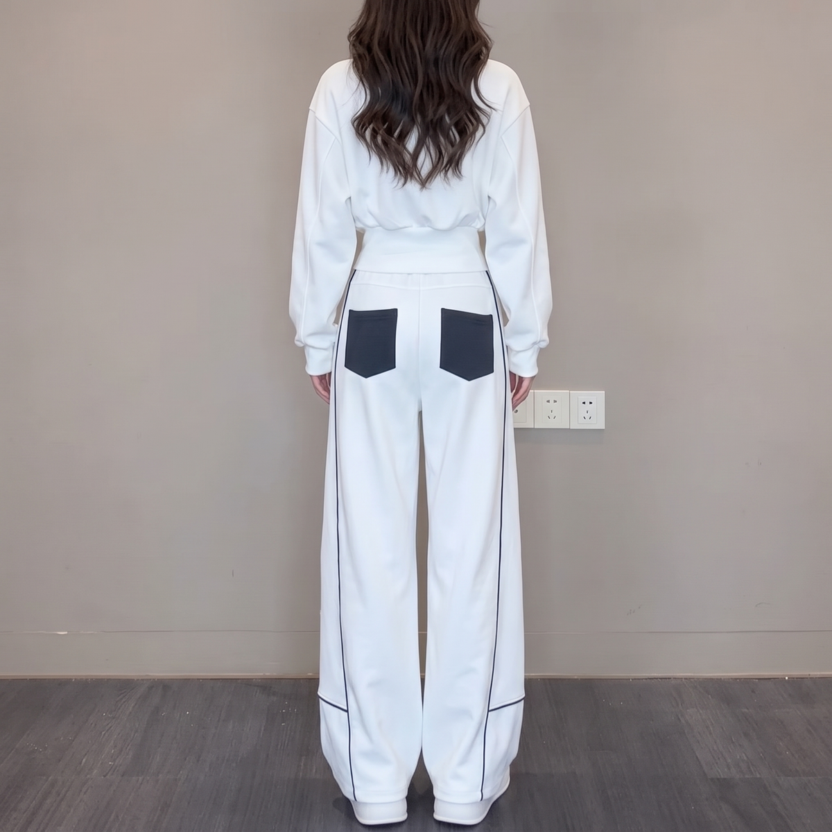 Back view of the Wilhelmina Two-Piece Set Striped Polo Wide-Leg in white, featuring contrast pocket details and relaxed wide-leg trousers. By BELLA HUDSON.
