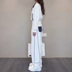 Side view of the Wilhelmina Two-Piece Set Striped Polo Wide-Leg in white, showcasing the relaxed top and flowing wide-leg trousers. By BELLA HUDSON.
