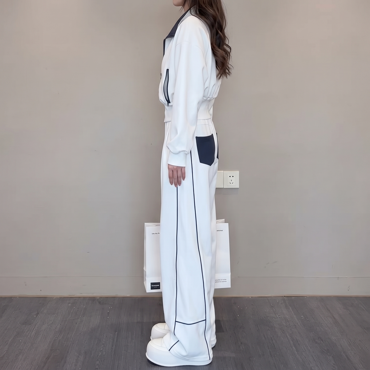 Side view of the Wilhelmina Two-Piece Set Striped Polo Wide-Leg in white, showcasing the relaxed top and flowing wide-leg trousers. By BELLA HUDSON.