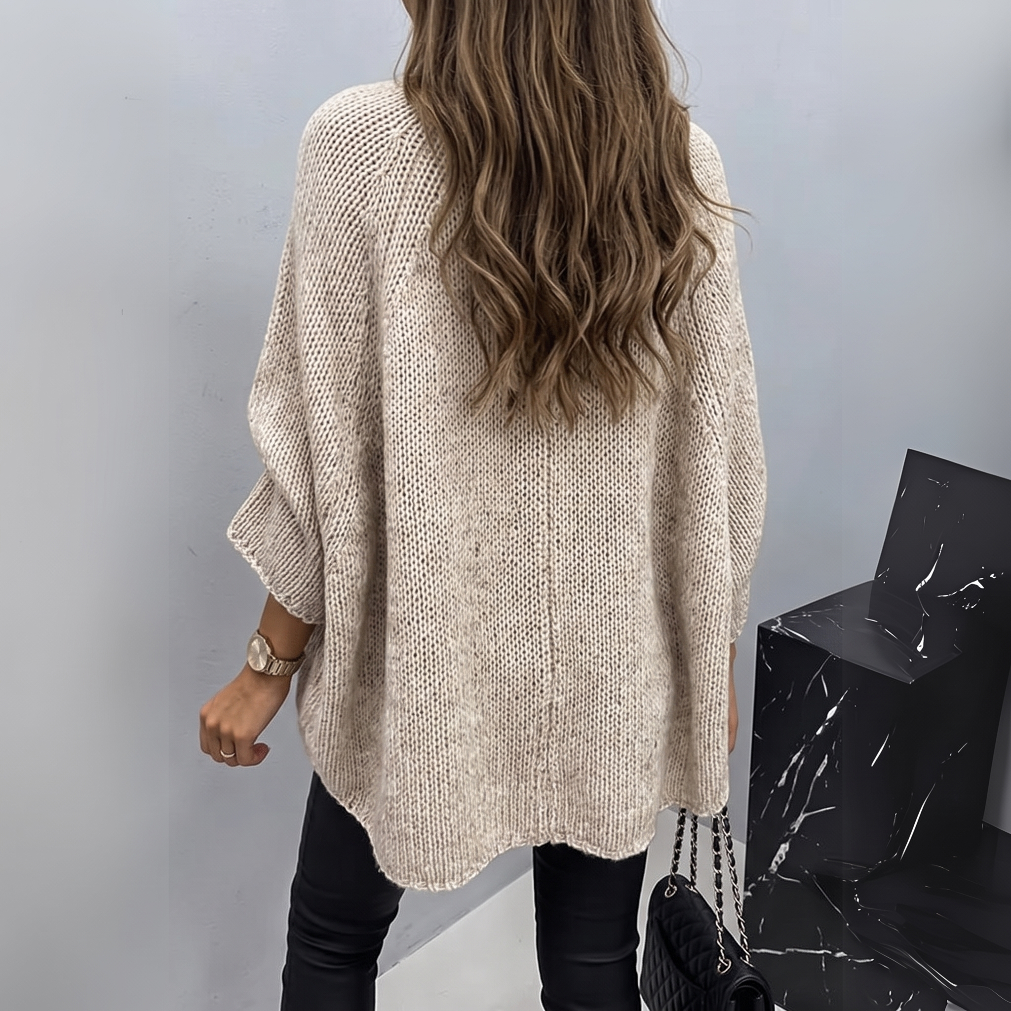 Back view of the Wilhelmine Sweater Oversized Batwing-Sleeve in beige, featuring a round neckline, wide batwing sleeves, textured knit fabric, and a relaxed oversized silhouette. Designed by Bella Hudson.