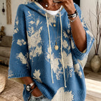 Winifred Blue hooded floral cape sweater featuring a drawstring hood, floral pattern, wide sleeves, and a relaxed oversized silhouette