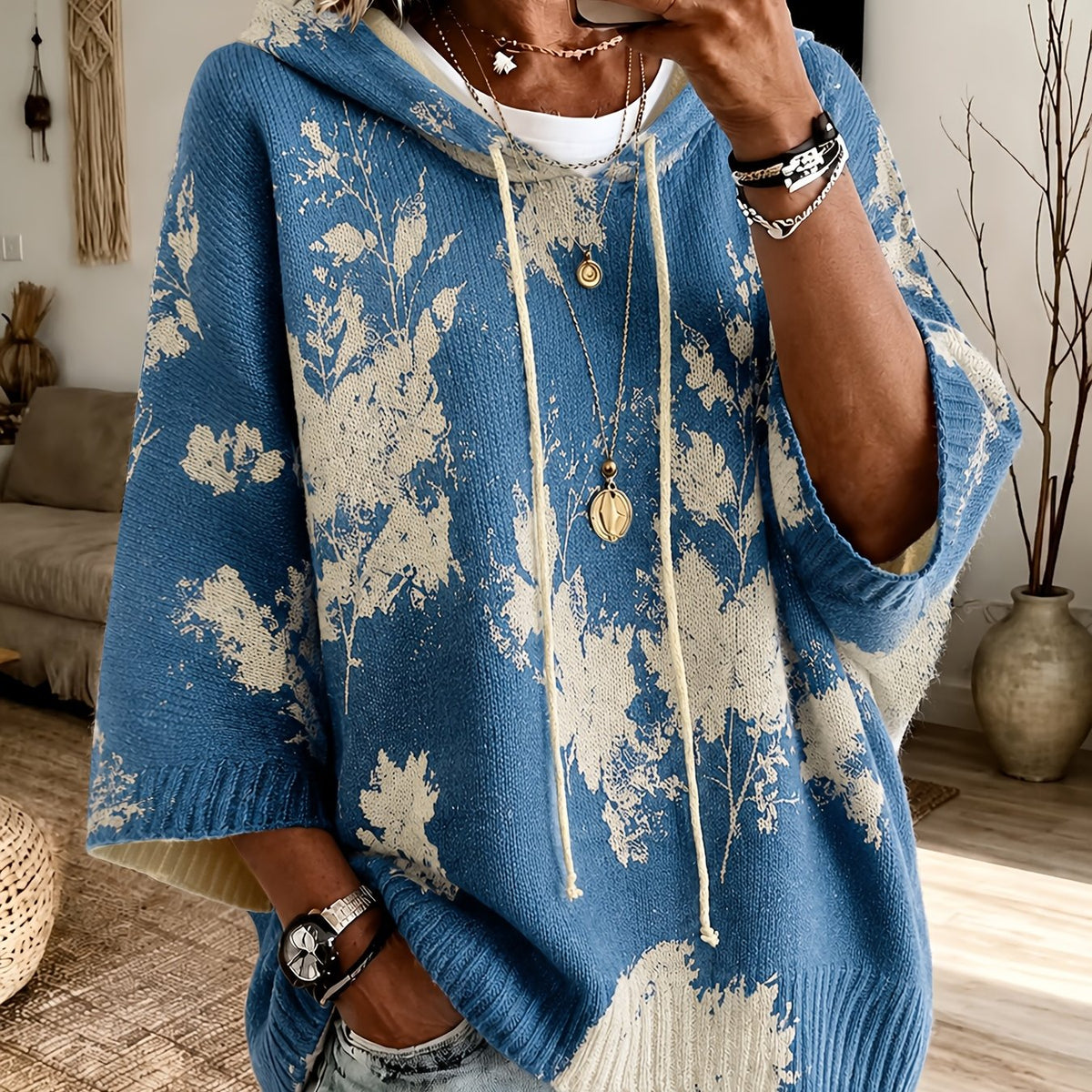 Winifred Blue hooded floral cape sweater featuring a drawstring hood, floral pattern, wide sleeves, and a relaxed oversized silhouette