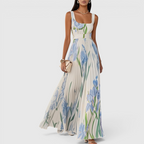 Front view of the Winnie Maxi Cocktail Dress Floral-Print Chiffon Square-Neck in light blue, featuring a square neckline, sleeveless design, fitted bodice, and a flowing floral-print chiffon silhouette. Designed by Bella Hudson.
