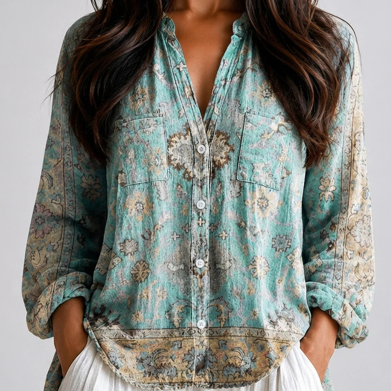 Close-up front view of blue green floral boho lightweight blouse with button front, chest pockets, and long sleeves BELLA HUDSON.
