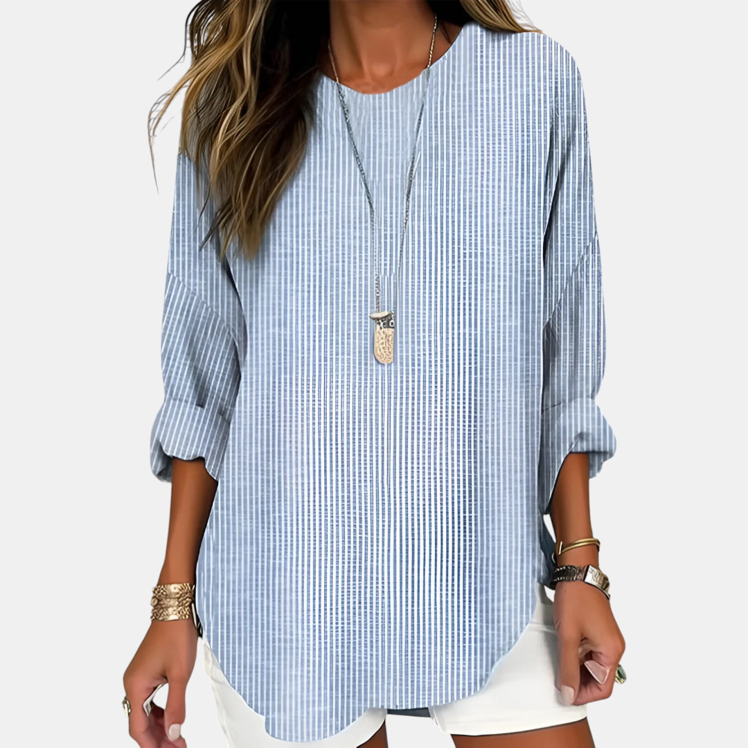 Front detail view of the Women's Boho Lightweight Blouse in blue, showcasing the relaxed fit, rolled sleeves, textured fabric, and curved hem. Designed by Bella Hudson.