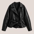 product view of Women's Cropped Biker Style Faux Leather Jacket in wine red highlighting the oversized collar, faux leather texture, stitching details, and waist belt designed by Bella Hudson.