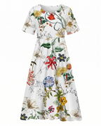 Front view of green floral print midi dress with short sleeves, empire waist and pockets by BELLA HUDSON