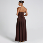 Back view of the Women's Wedding Guest Maxi Dress with a strapless bodice and high-split design in brown, showcasing the clean strapless back, gathered waistline, and graceful full-length silhouette. Designed by Bella Hudson.
