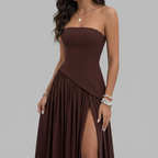 Detail view of the Women's Wedding Guest Maxi Dress with a strapless bodice and high-split design in brown, highlighting the flowing drape, gathered skirt, and elegant scarf-style accent. Designed by Bella Hudson.