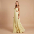 Side view of the Women's Wedding Guest Maxi Dress with a strapless bodice and high-split design in light yellow, showcasing the flowing pleated skirt, flattering fitted bodice, and graceful side profile. Designed by Bella Hudson.