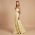 Side view of the Women's Wedding Guest Maxi Dress with a strapless bodice and high-split design in light yellow, showcasing the flowing pleated skirt, flattering fitted bodice, and graceful side profile. Designed by Bella Hudson.