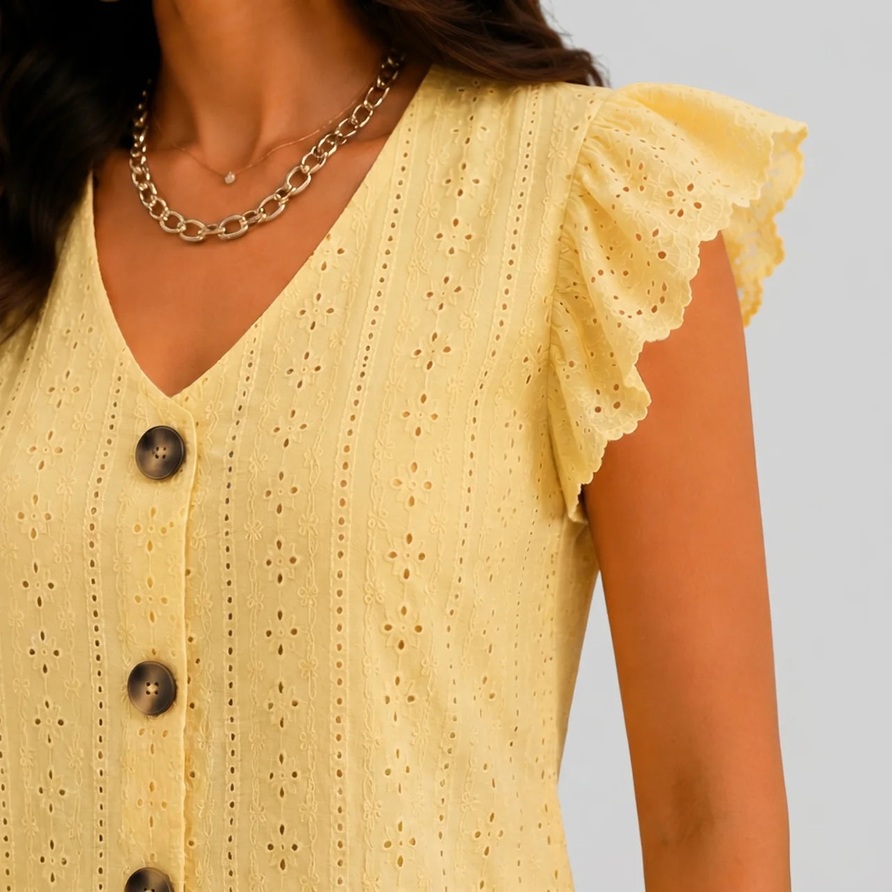 Close-up view of yellow ruffle sleeve knit top with button-front detail and V-neckline by BELLA HUDSON