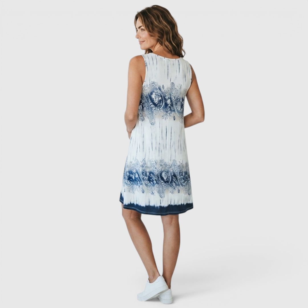 Back view of the Zinnia A-Line Dress Sleeveless Ink-Wash-Print in white, highlighting the sleeveless design, flowing A-line silhouette, and blue ink-wash print. Designed by Bella Hudson.